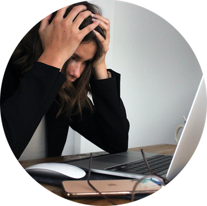 Women with head in hands in front of a laptop screen